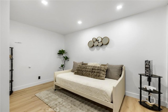 living area with recessed lighting, baseboards, and wood finished floors