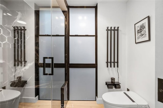 full bath featuring a shower, toilet, and wood finished floors