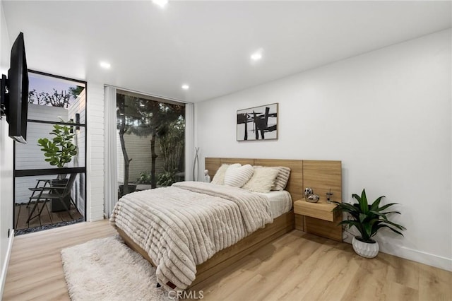 bedroom featuring recessed lighting, light wood-type flooring, and access to exterior