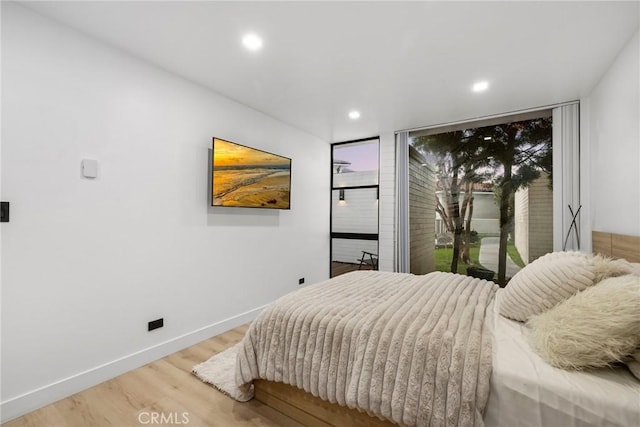 bedroom featuring light wood finished floors, recessed lighting, baseboards, and access to exterior