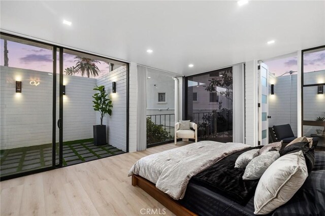 bedroom featuring a wall of windows, wood finished floors, and recessed lighting