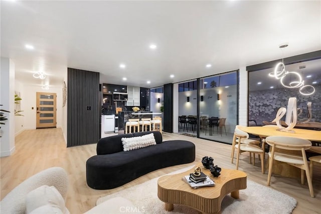 living room with recessed lighting, light wood-style floors, and a chandelier