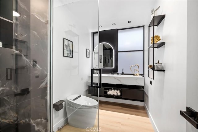 full bathroom featuring vanity, wood finished floors, a stall shower, and baseboards