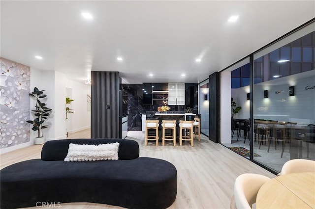 living room featuring recessed lighting, light wood-style floors, and baseboards