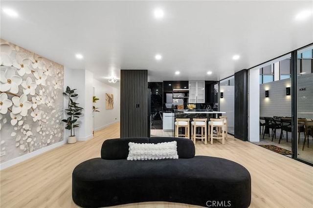 living area with recessed lighting, baseboards, and light wood-style floors