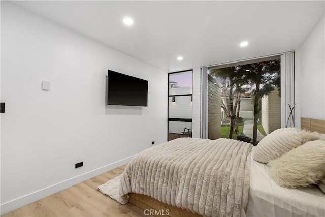 bedroom with wood finished floors, baseboards, recessed lighting, access to outside, and multiple windows