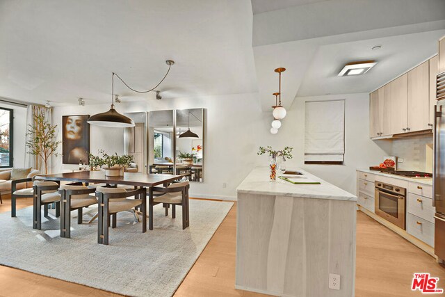 dining space with light wood-type flooring and sink