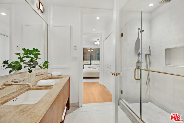 bathroom featuring vanity, tile patterned floors, and a shower with door