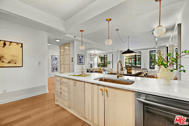 kitchen featuring pendant lighting, dishwasher, light brown cabinetry, sink, and light hardwood / wood-style floors