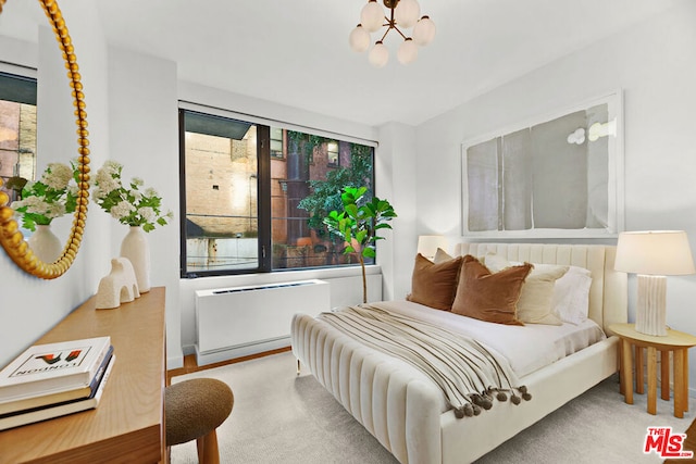 bedroom with radiator, a chandelier, and multiple windows