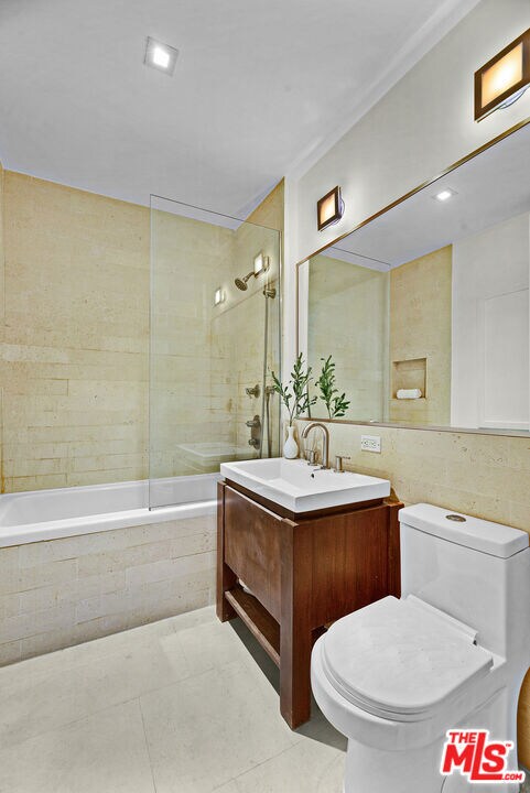 full bathroom with toilet, tile patterned flooring, tiled shower / bath, and vanity