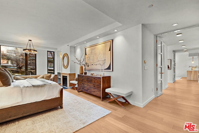 bedroom featuring light wood-type flooring and a chandelier