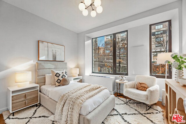 bedroom featuring a chandelier and light wood-type flooring