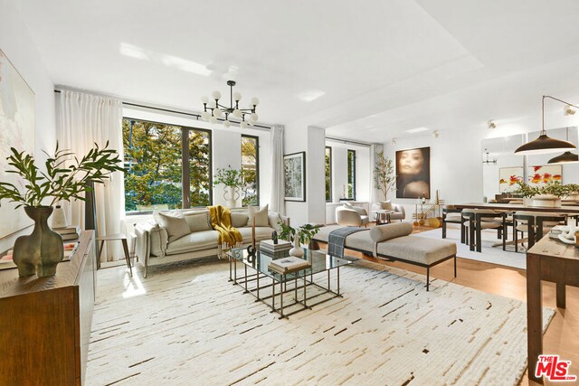 living room with light hardwood / wood-style flooring and a notable chandelier