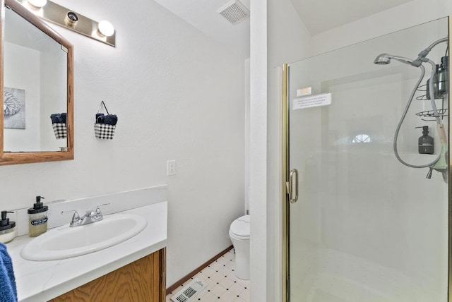 bathroom featuring vanity, toilet, and a shower with shower door