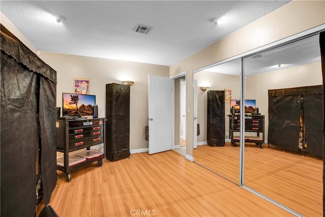 workout area with light hardwood / wood-style floors