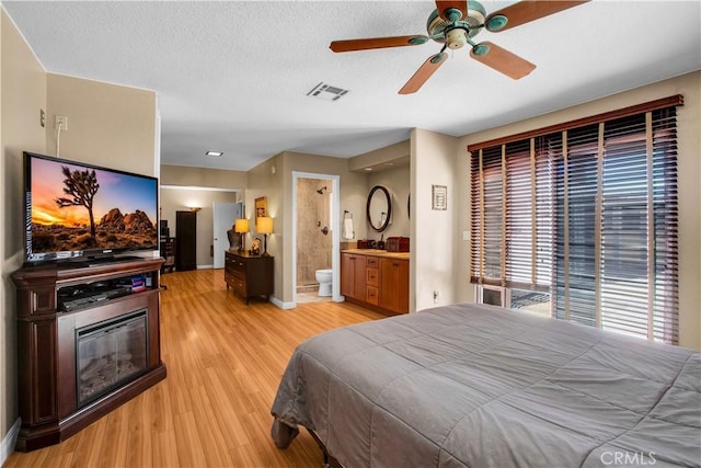 bedroom featuring ceiling fan, ensuite bathroom, and light hardwood / wood-style floors