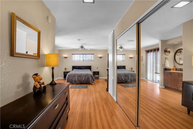 bedroom featuring connected bathroom and light hardwood / wood-style floors