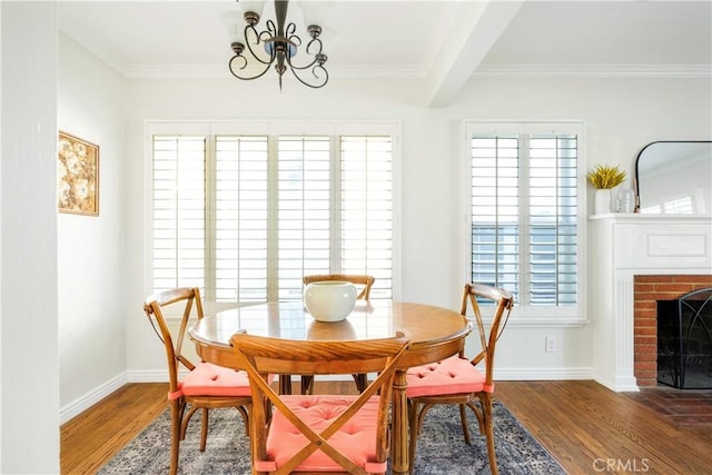 dining space featuring a fireplace, dark hardwood / wood-style flooring, a healthy amount of sunlight, and crown molding