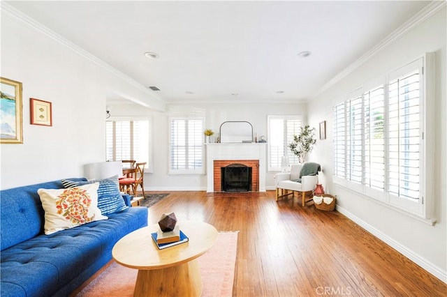 living room featuring crown molding, a fireplace, and wood-type flooring