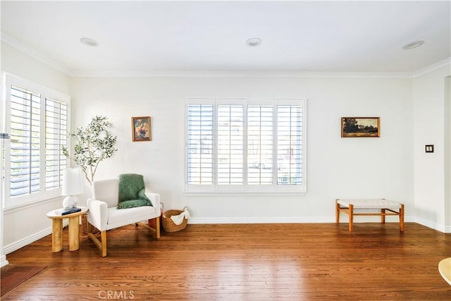 sitting room with hardwood / wood-style floors and crown molding