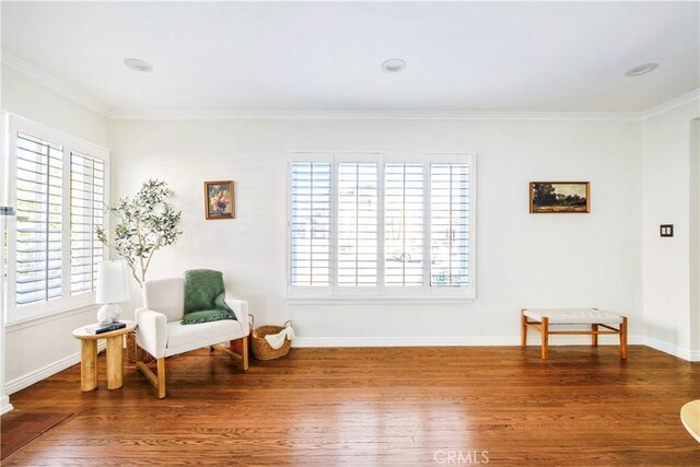 sitting room with wood finished floors, a wealth of natural light, and crown molding