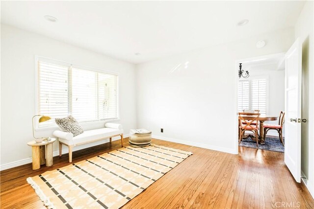 living area with baseboards and wood finished floors