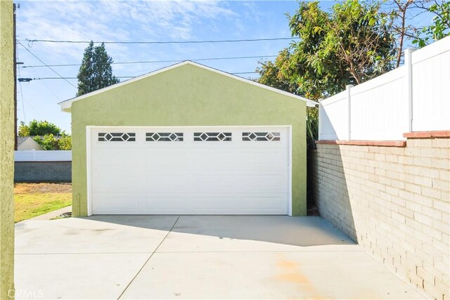 detached garage featuring fence