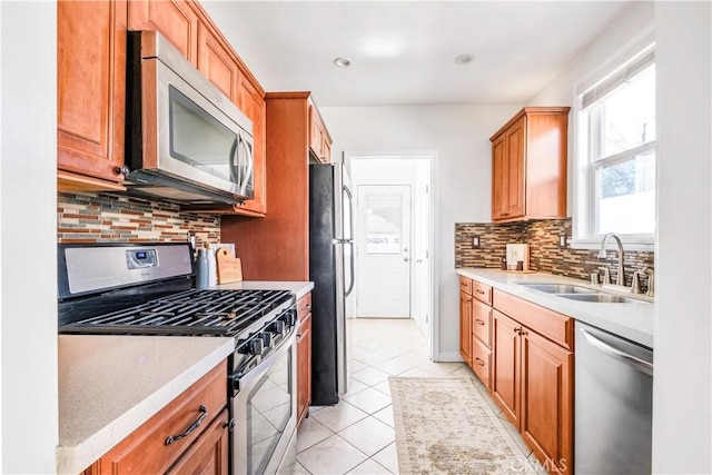 kitchen with sink, stainless steel appliances, light tile patterned floors, and tasteful backsplash