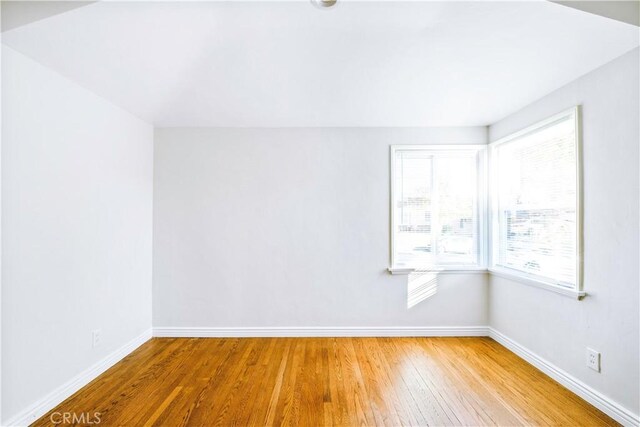 spare room featuring wood finished floors and baseboards