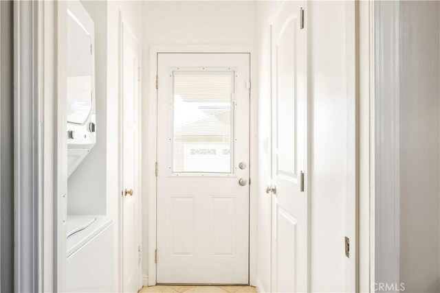 doorway to outside with stacked washer / dryer