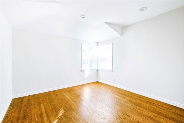 unfurnished room featuring recessed lighting, baseboards, and wood finished floors