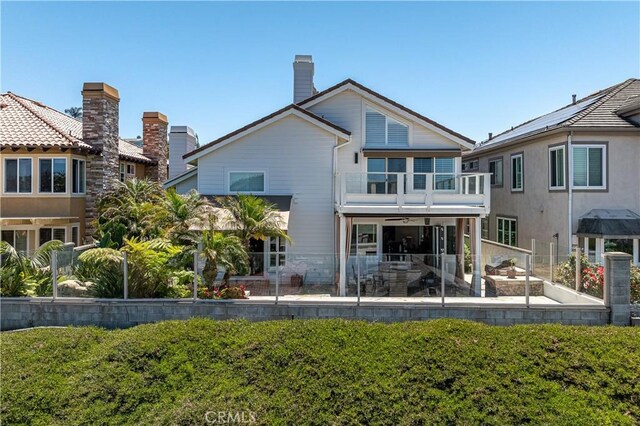 rear view of house with a patio area and a balcony