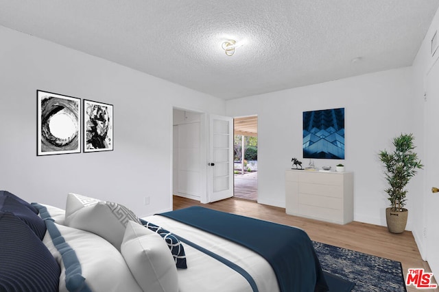 bedroom featuring a textured ceiling and wood-type flooring