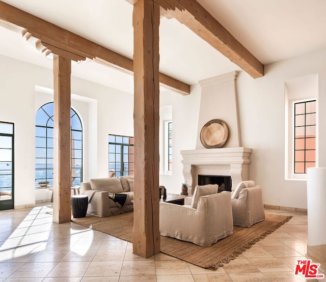 living room featuring beam ceiling and a fireplace