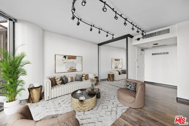 living room with a wall of windows and dark hardwood / wood-style flooring