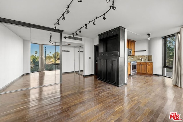 unfurnished living room with floor to ceiling windows and hardwood / wood-style flooring