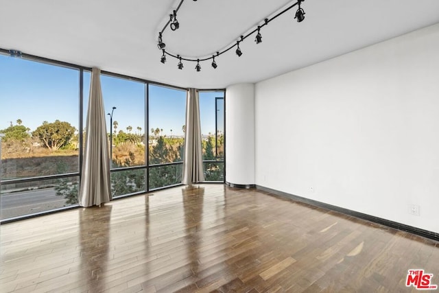 unfurnished room with wood-type flooring and expansive windows