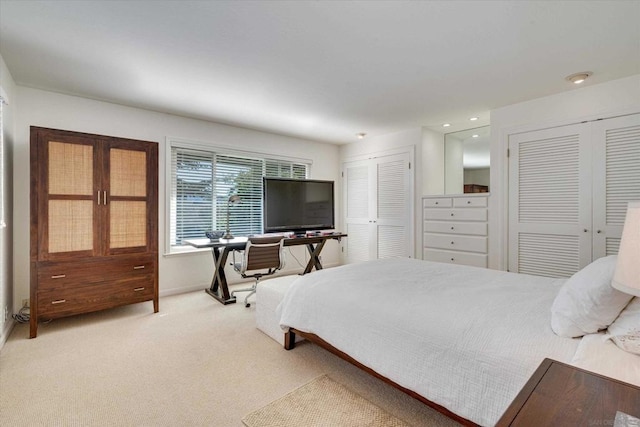 bedroom with multiple closets and carpet