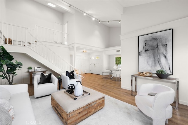 living room with light hardwood / wood-style flooring and a high ceiling