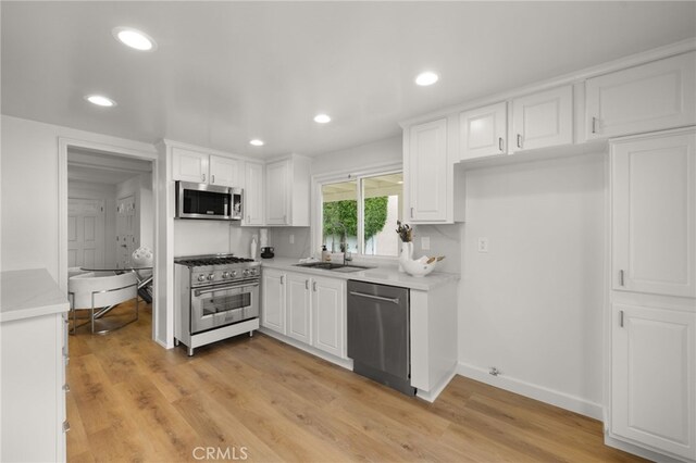 kitchen with stainless steel appliances, backsplash, white cabinetry, and sink