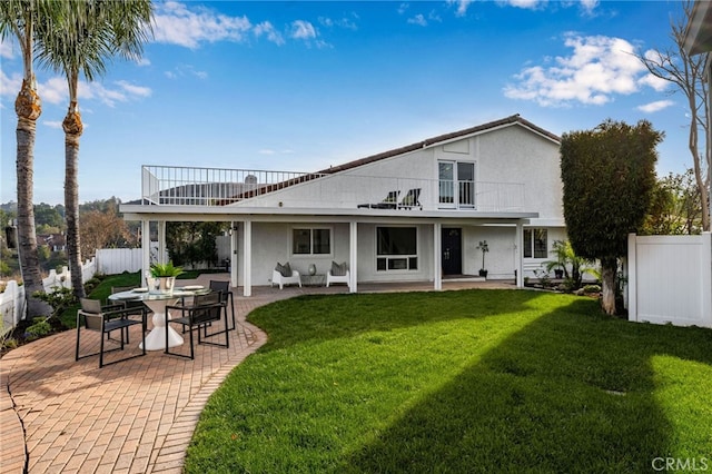 back of house with a balcony, a yard, and a patio