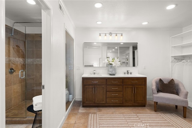 bathroom with a shower with shower door, vanity, ornamental molding, and tile patterned flooring