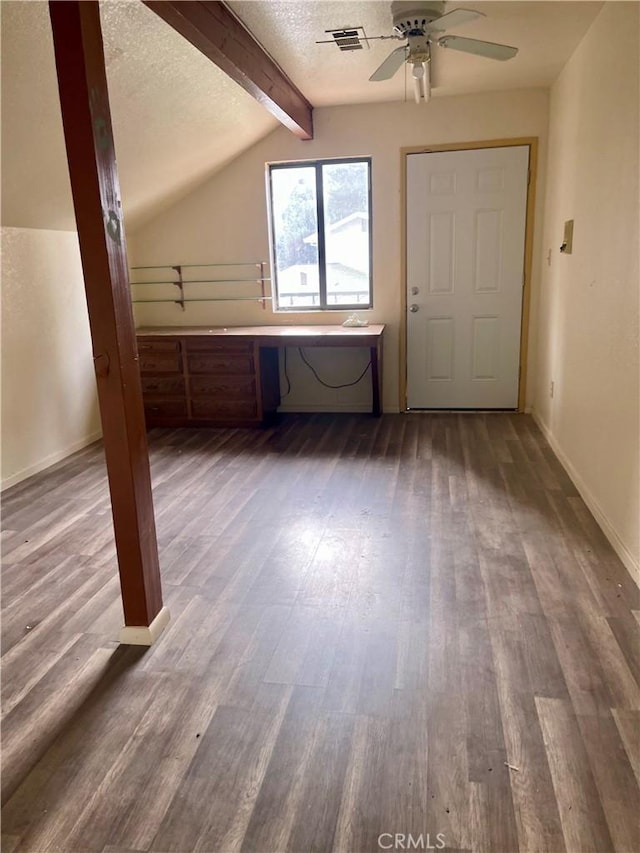 bonus room with a textured ceiling, ceiling fan, dark hardwood / wood-style flooring, and vaulted ceiling with beams