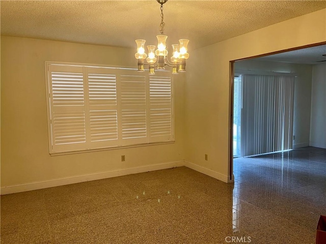 unfurnished room with a notable chandelier and a textured ceiling