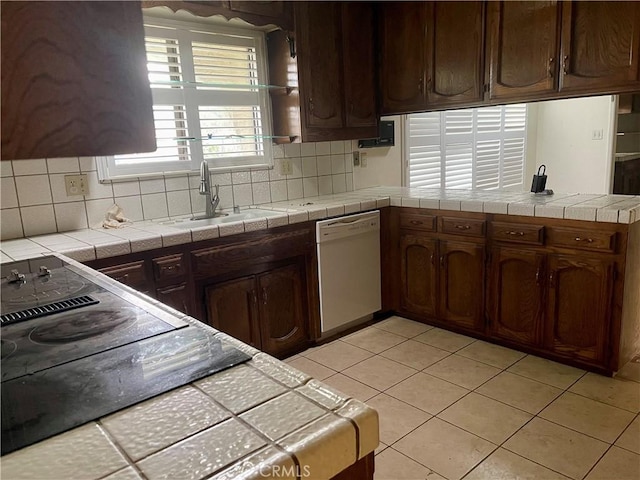 kitchen featuring sink, dishwasher, tile counters, and tasteful backsplash