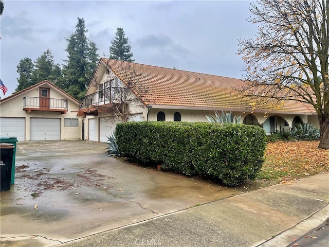 view of front of home with a garage and a balcony