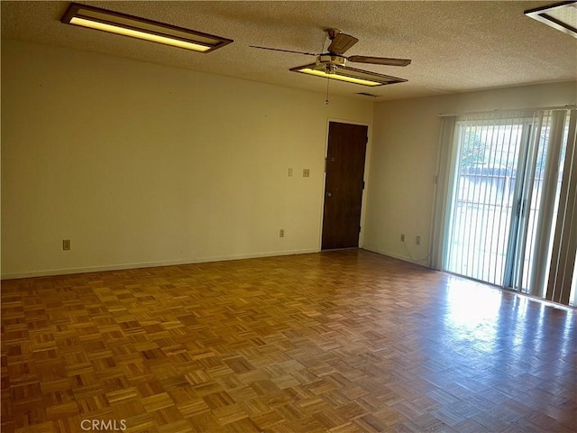 unfurnished room with a textured ceiling, ceiling fan, and parquet floors