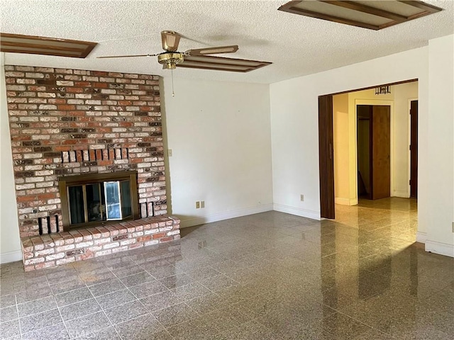 unfurnished living room with ceiling fan, a fireplace, and a textured ceiling