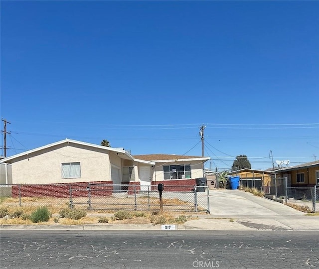 single story home featuring brick siding, a fenced front yard, and stucco siding